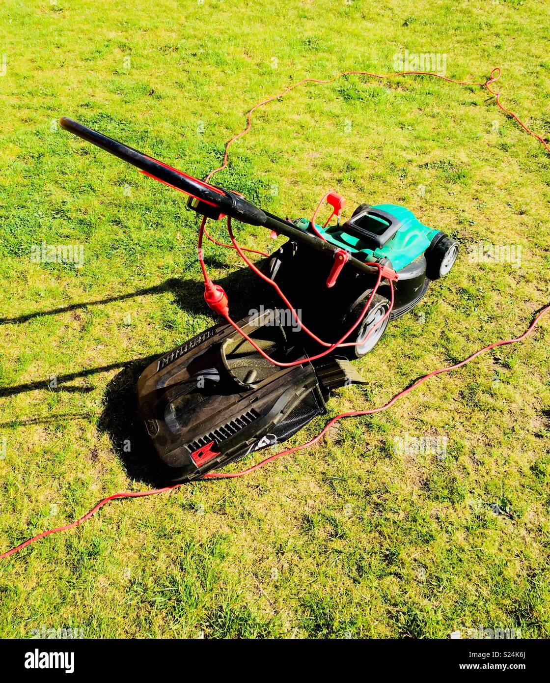 Lawnmower on freshly cut grass Stock Photo