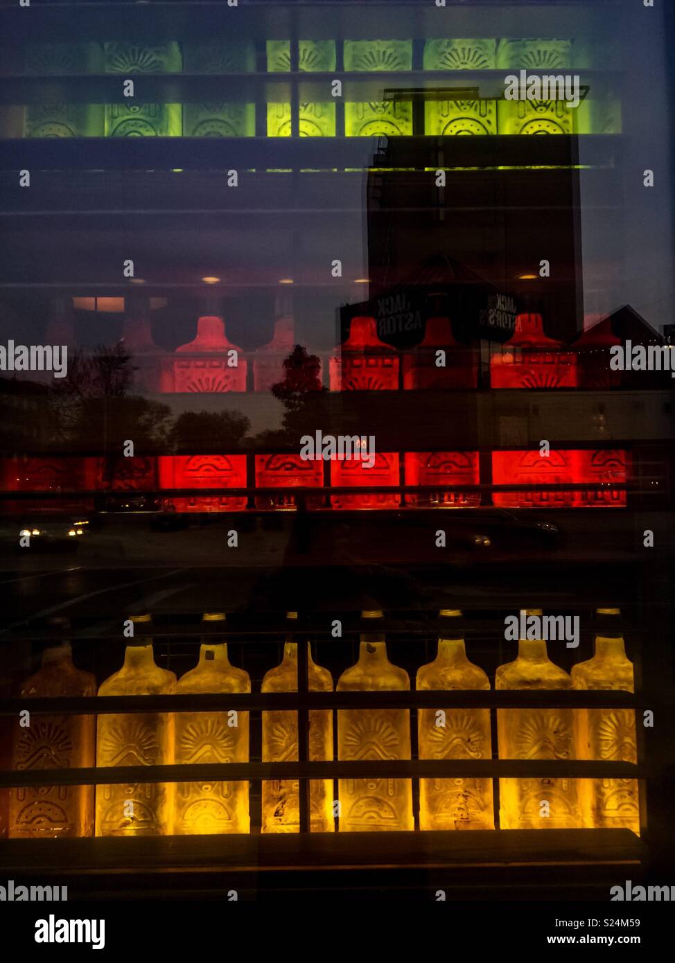 Liquor cabinet dimly lit. Alcoholic beverages in many colours neatly arranged behind glass, Ontario, Canada. - Smartphone Captured Stock Image