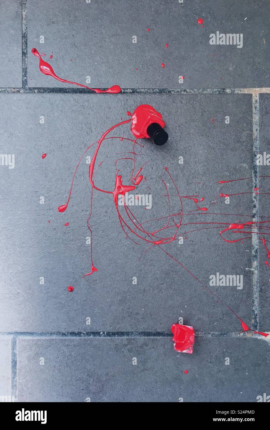 Broken red nail varnish bottle on a tiled floor - Smartphone Captured Stock Image