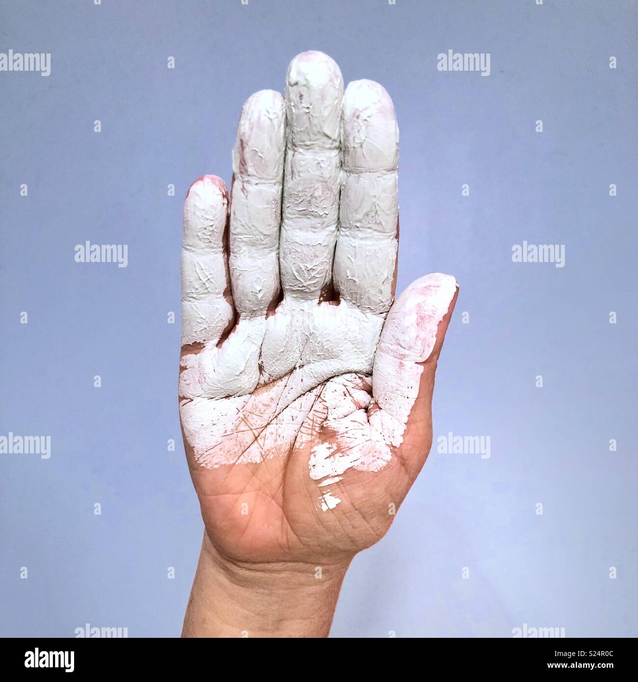 A closeup of the palm of a Caucasian hand covered in white paint - Smartphone Captured Stock Image