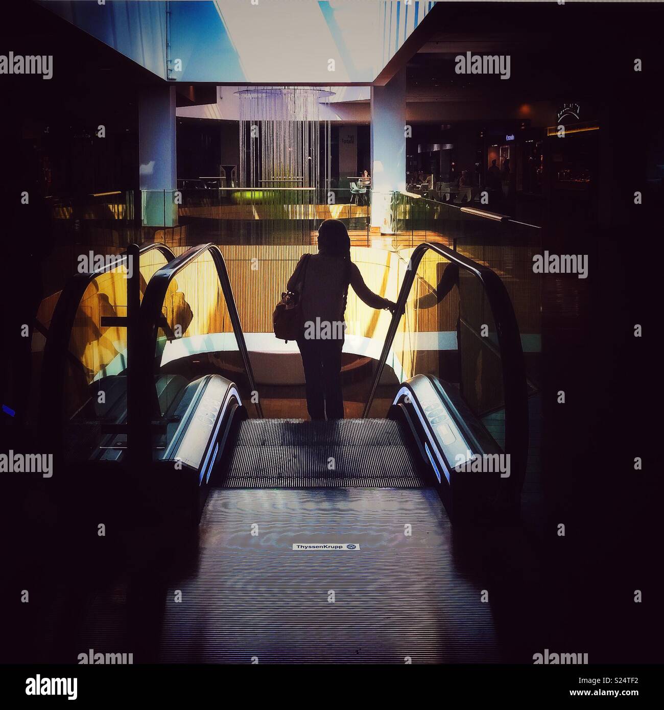 Beautiful dark silouhette of a woman on an automated escalator in a mall, France. - Smartphone Captured Stock Image