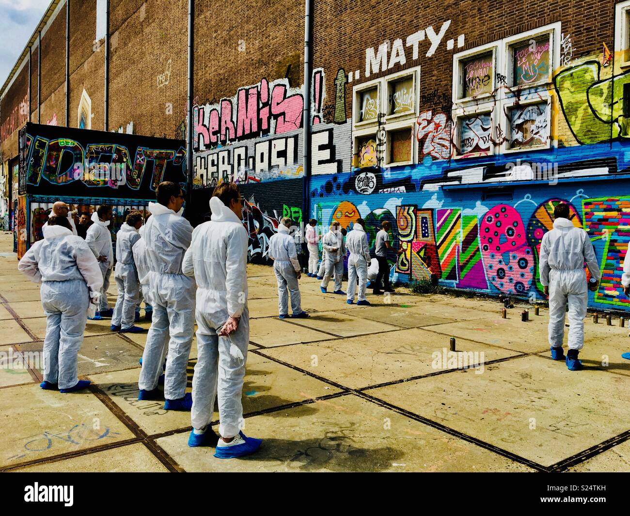 Group of graffiti artists working on a wall in NDSM, Amsterdam - Smartphone Captured Stock Image