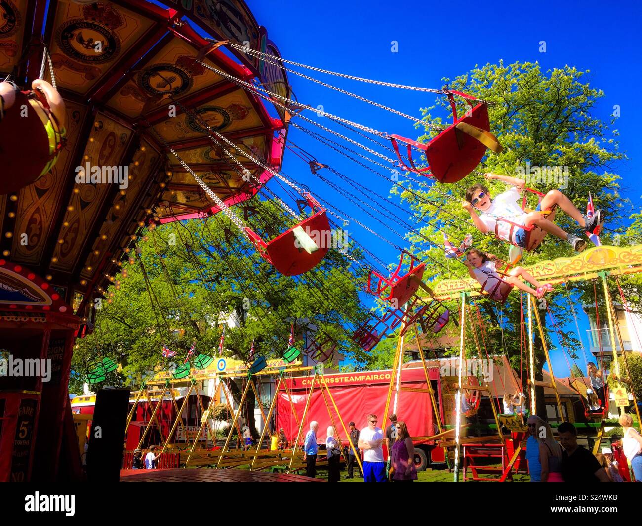 Swinging chairs merry go round Stock Photo - Alamy