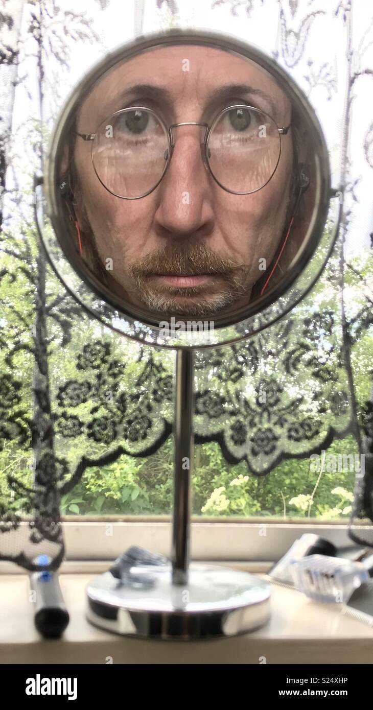Strange face reflected in a mirror through a window Stock Photo Alamy