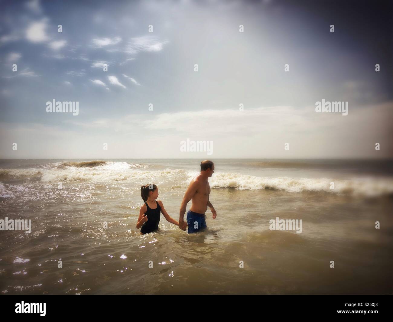 Father and daughter in the ocean - Smartphone Captured Stock Image