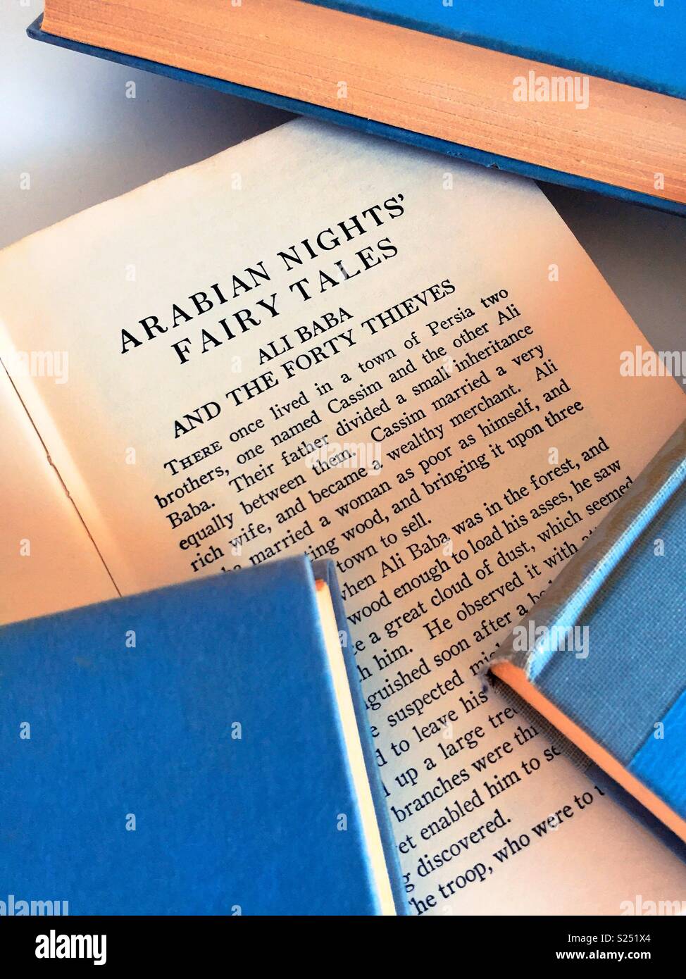 Close up of Arabian nights book open with other hardbound books, United States. Stock Photo
