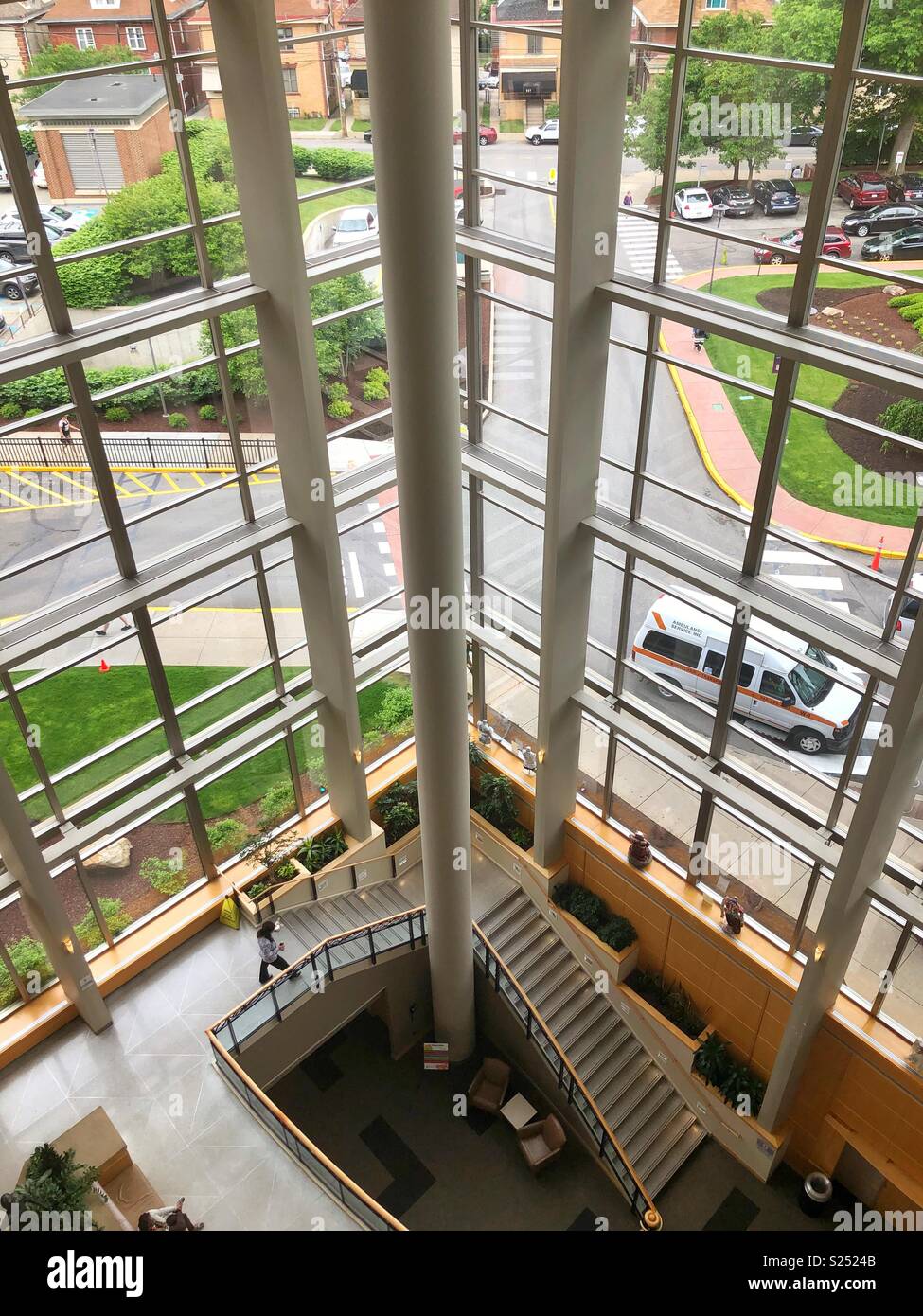 A view looking down into a large glass atrium from above Stock Photo