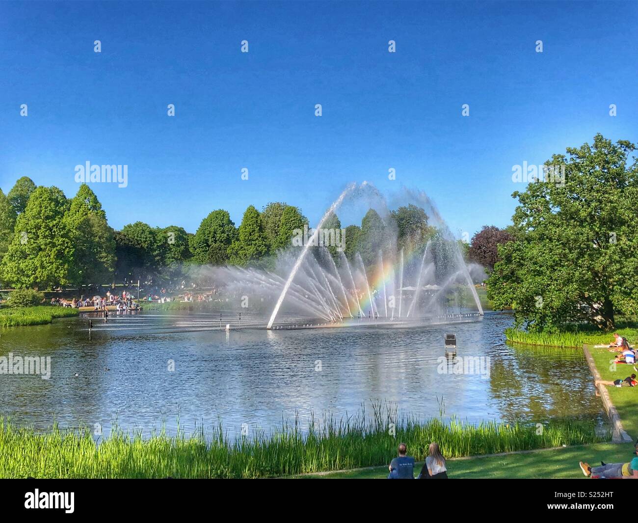 Water show with a rainbow in Planten un Blomen, Hamburg, Germany. - Smartphone Captured Stock Image