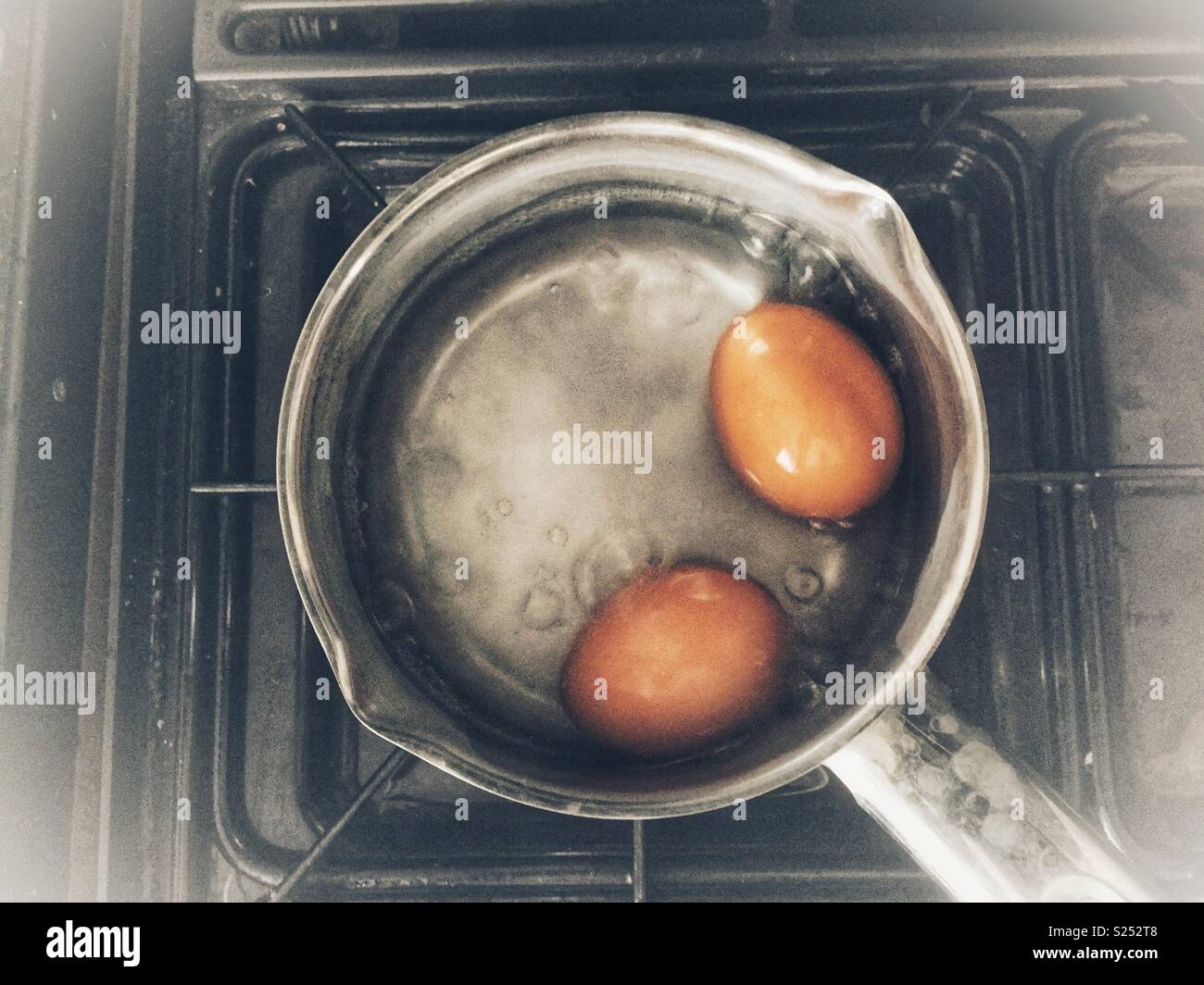 Boiling eggs in a pan on a gas hob. Stock Photo