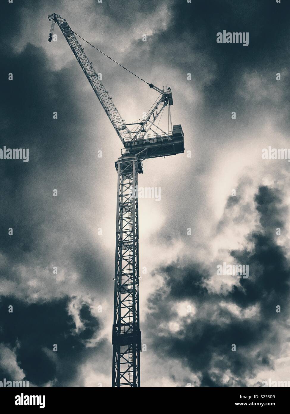 A crane on a construction site against a cloudy sky - Smartphone Captured Stock Image