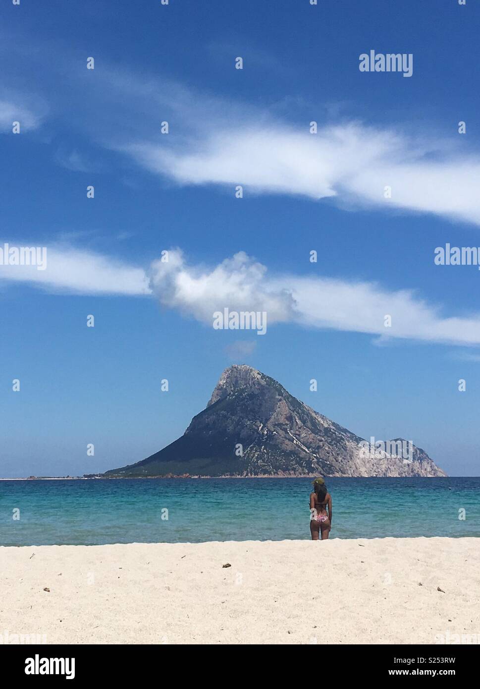 A woman looking at the Tavolara island, Sardinia Stock Photo