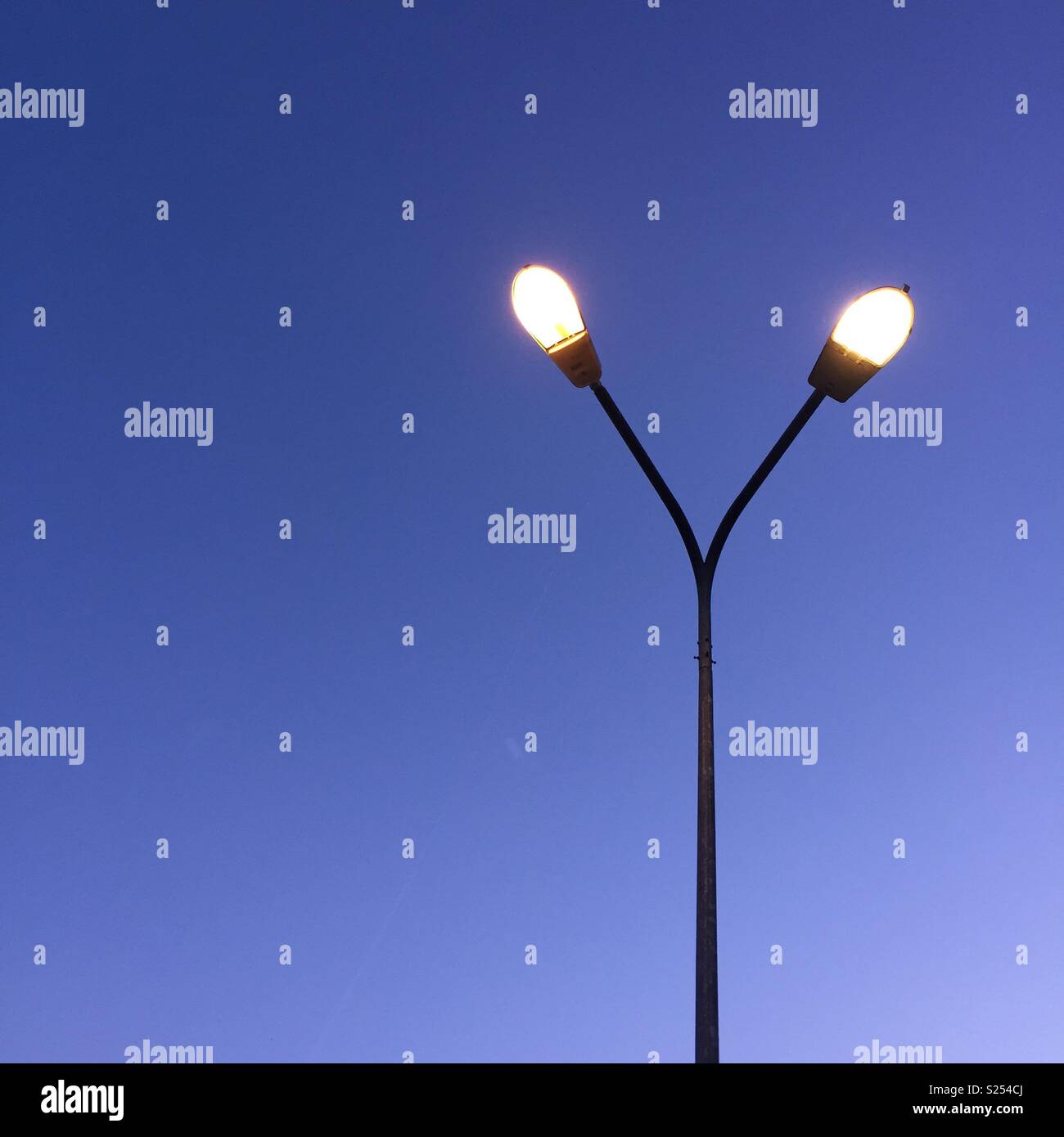 Lamp post with lightings on and deep blue belt on a background. - Smartphone Captured Stock Image