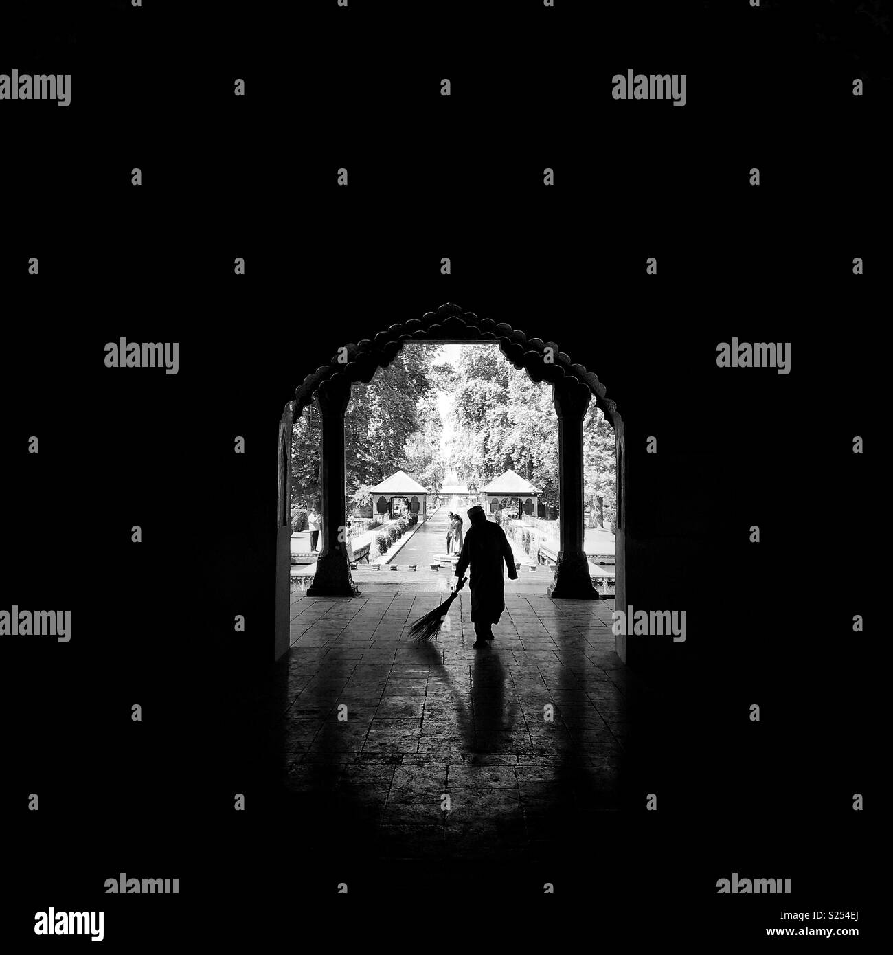 A caretaker sweeps at Shalimar garden in Srinagar, Kashmir of india. - Smartphone Captured Stock Image
