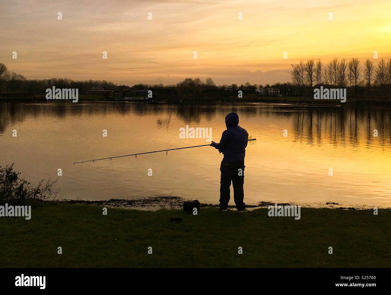 Silhouette of fisherman at sunset Stock Photo