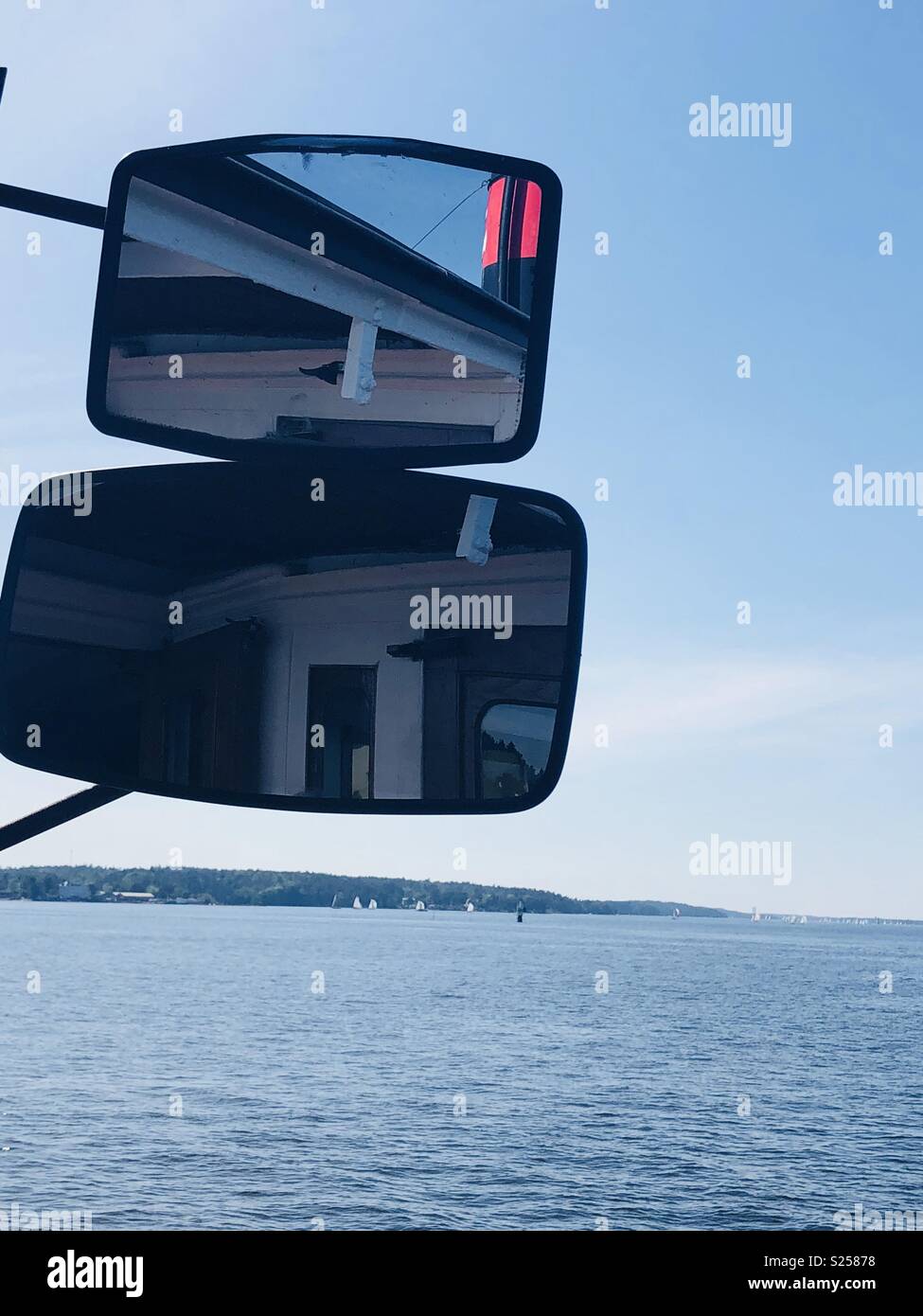 Wing mirror on a boat giving a view from behind Stock Photo