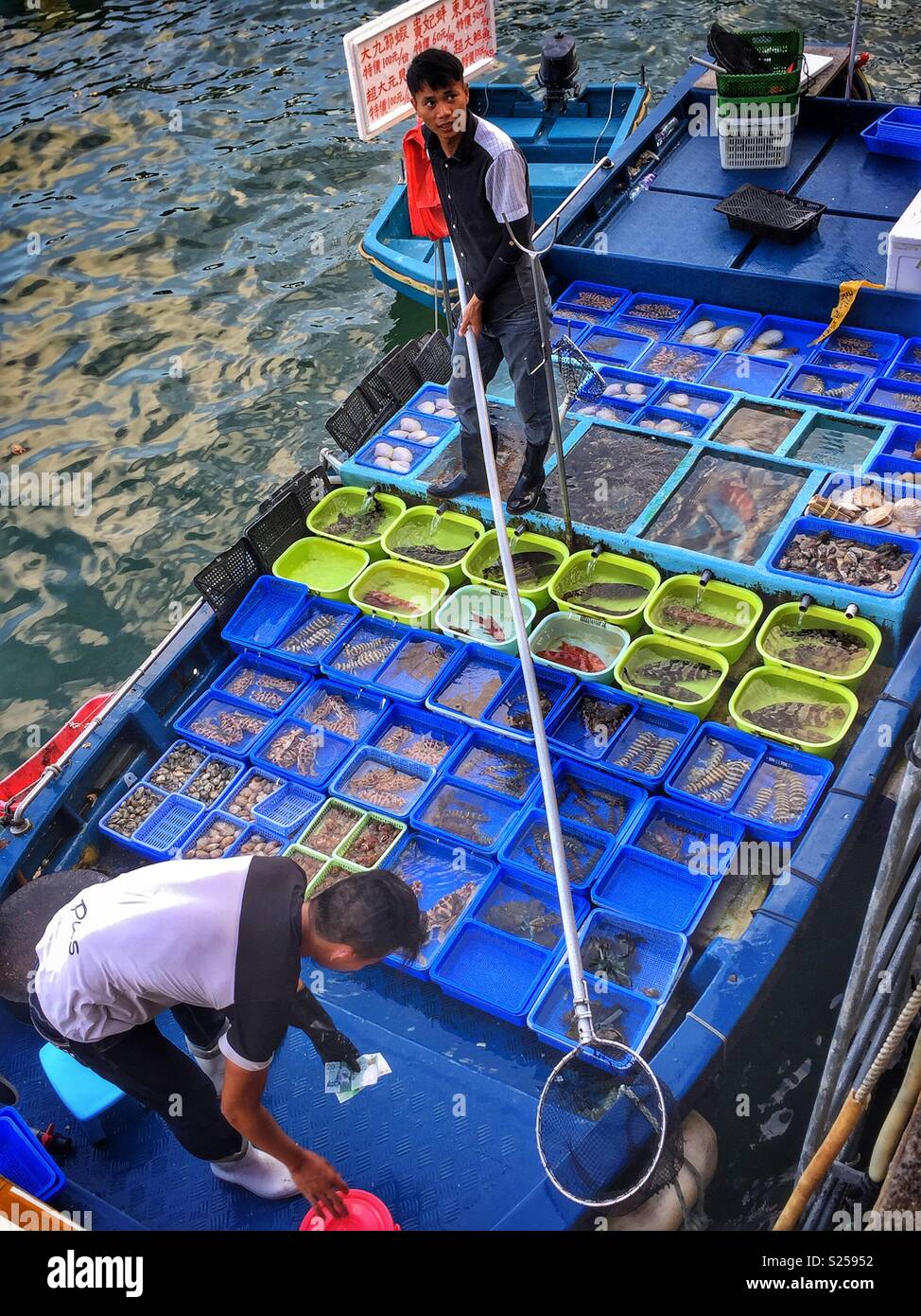 Fishermen sell locally caught fish and seafood at Sai Kung waterfront, New Territories, Hong Kong - Smartphone Captured Stock Image