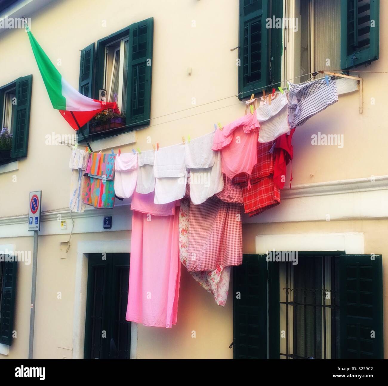Drying laundry and Italian flag hanging outside a house in Trieste, Italy. - Smartphone Captured Stock Image