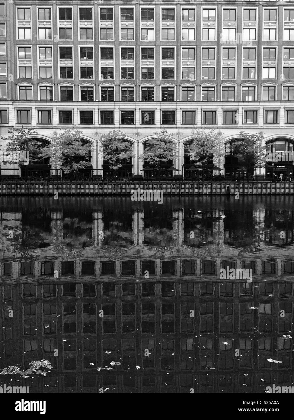 Reflection of old buildings alongside canal, Canary Wharf, East London Stock Photo