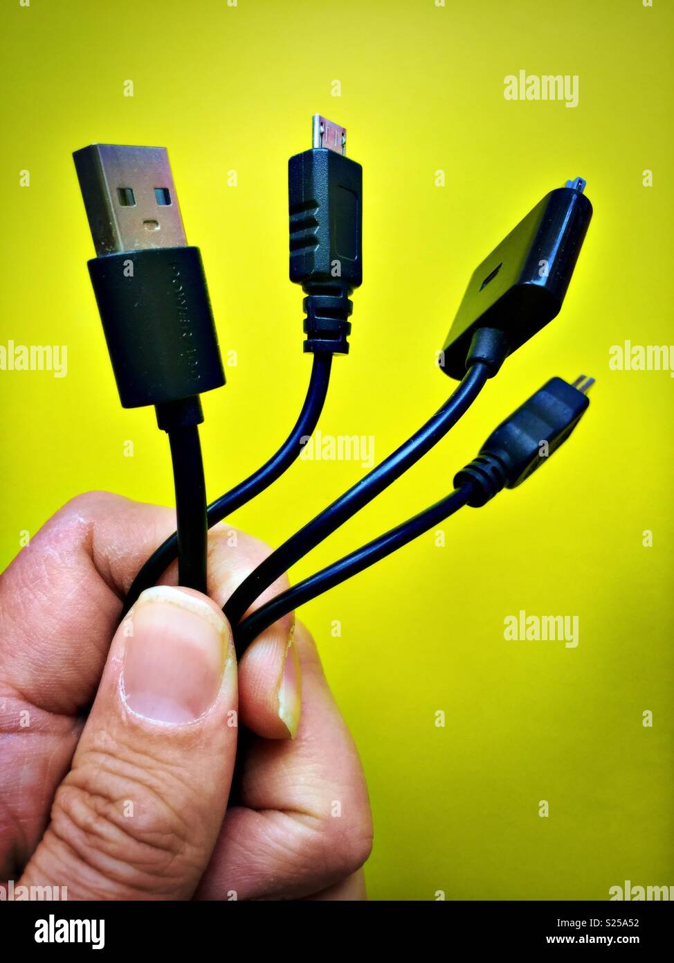 Hand holding myriad of different  USB and iPhone/ipad cable connection options. - Smartphone Captured Stock Image