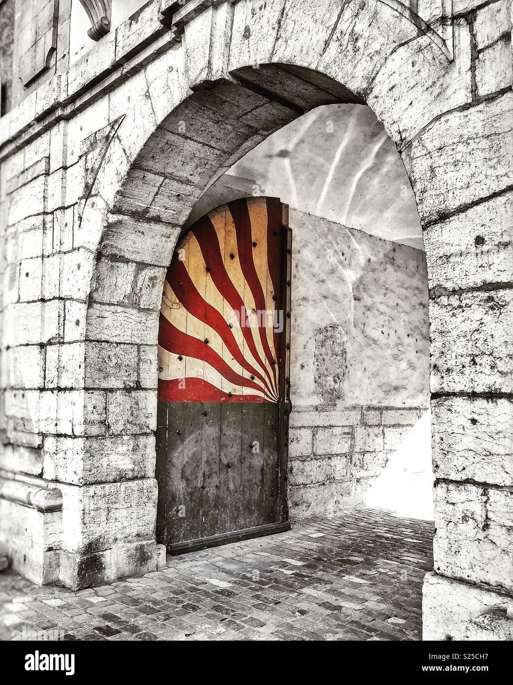 Medieval gateway with a brightly painted open door - Smartphone Captured Stock Image