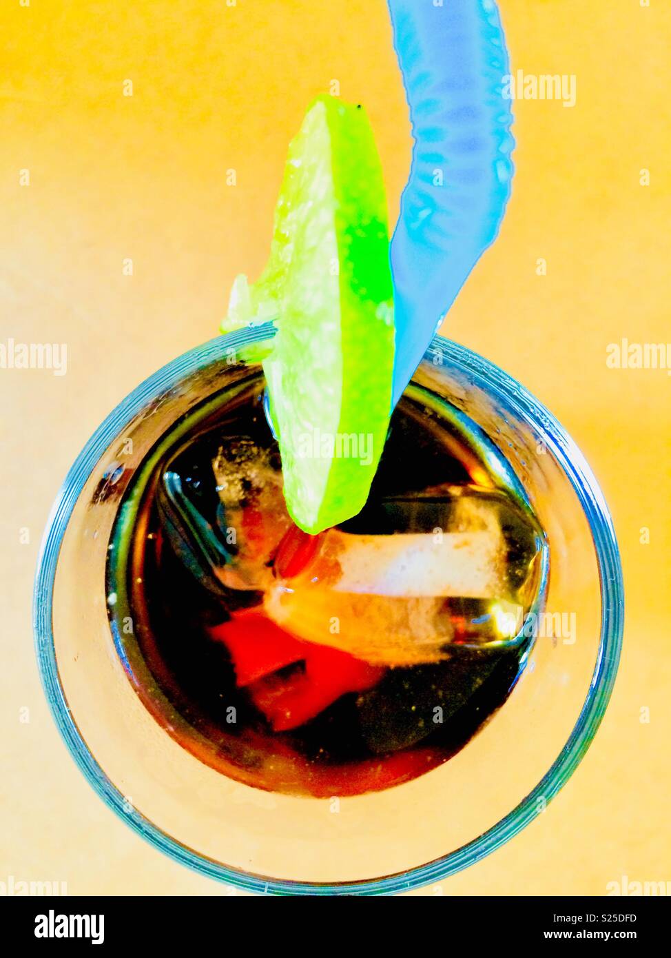 Aerial view of drink with ice cubes, slice of lime and blue straw - Smartphone Captured Stock Image