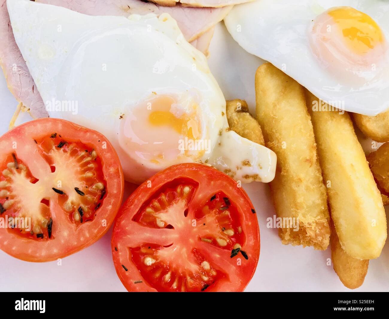 Ham, chips and eggs with grilled tomato Stock Photo Alamy