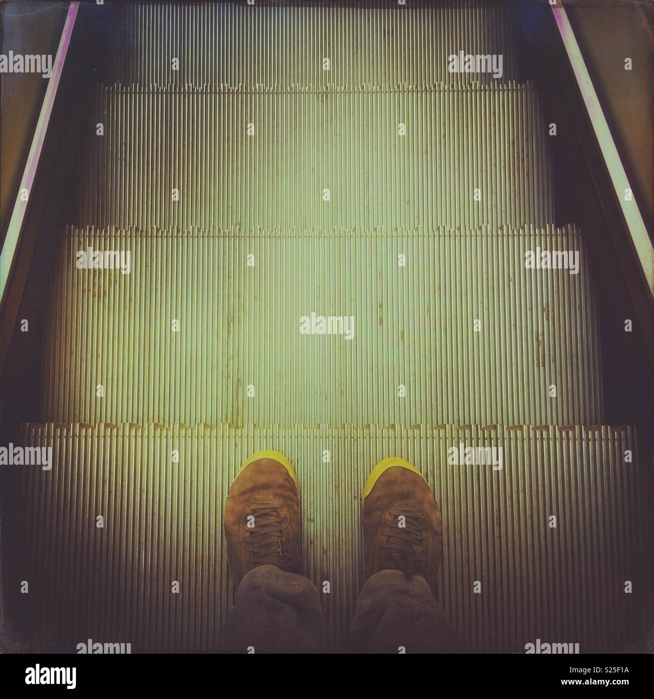 Looking down at the shoes on an escalator. - Smartphone Captured Stock Image