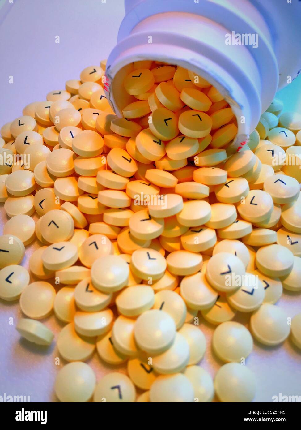 Still life of baby aspirin spilling out of a pill container, USA - Smartphone Captured Stock Image