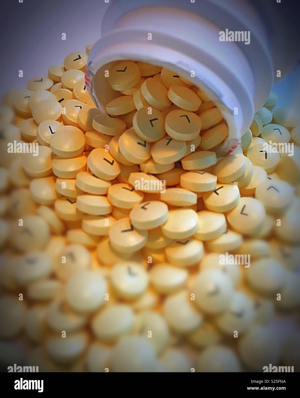 Still life of baby aspirin spilling out of a pill container, USA - Smartphone Captured Stock Image