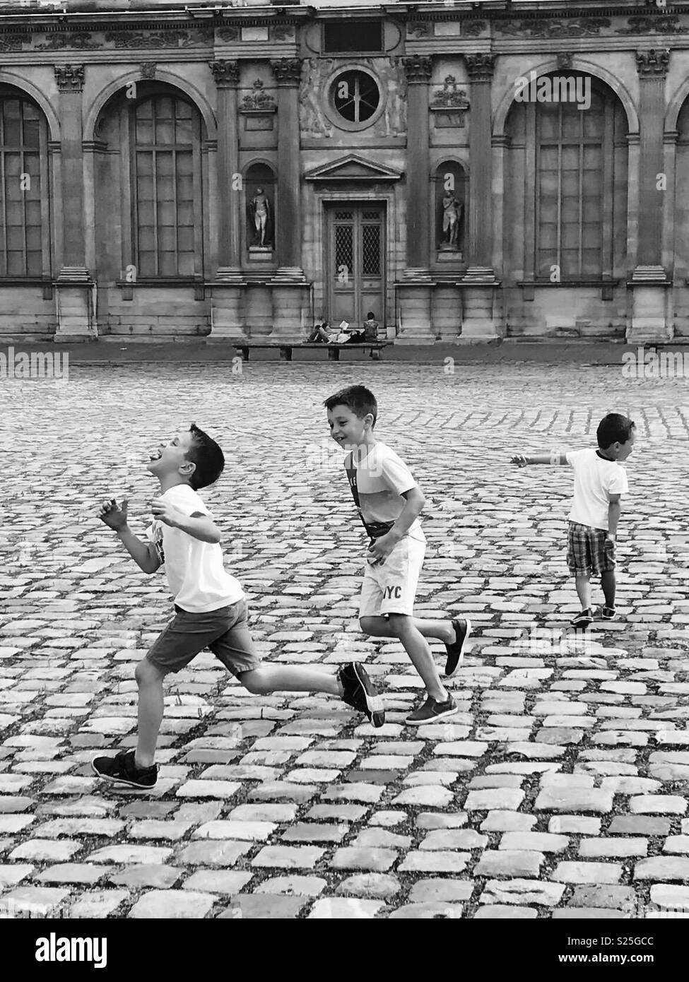 Tag your it. Kids playing tag at The louvre in Paris France. Stock Photo