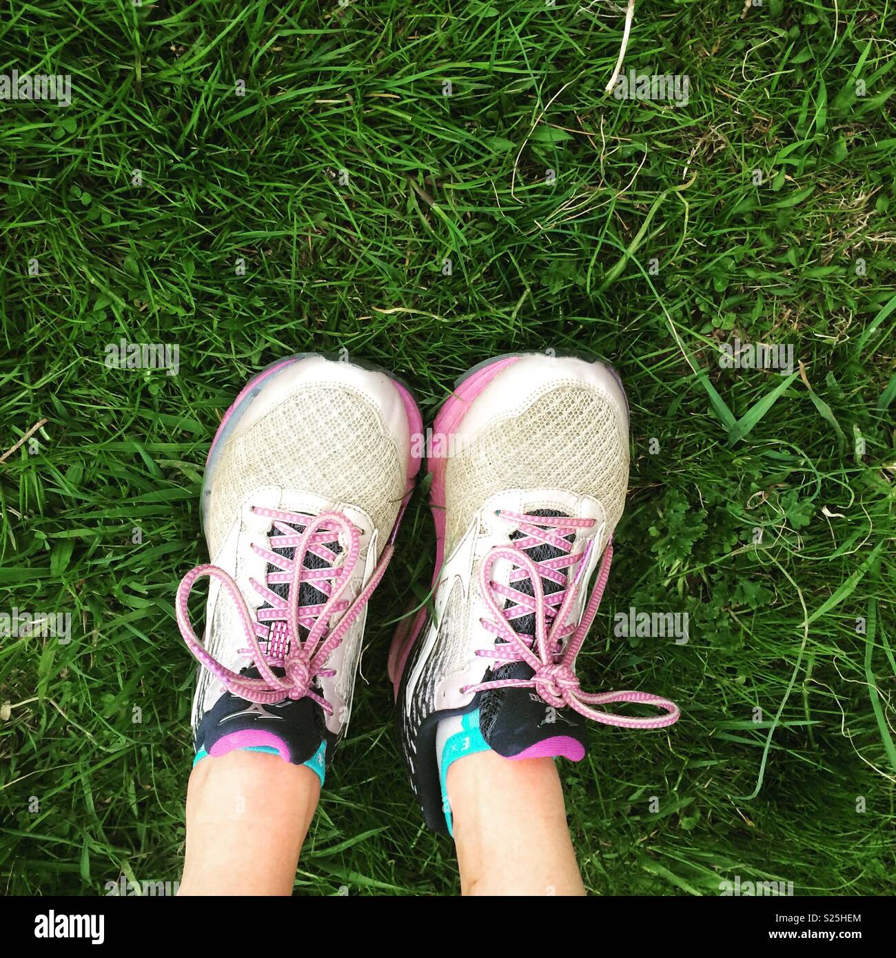 Legs wearing running shoes stretched out on grass Stock Photo Alamy