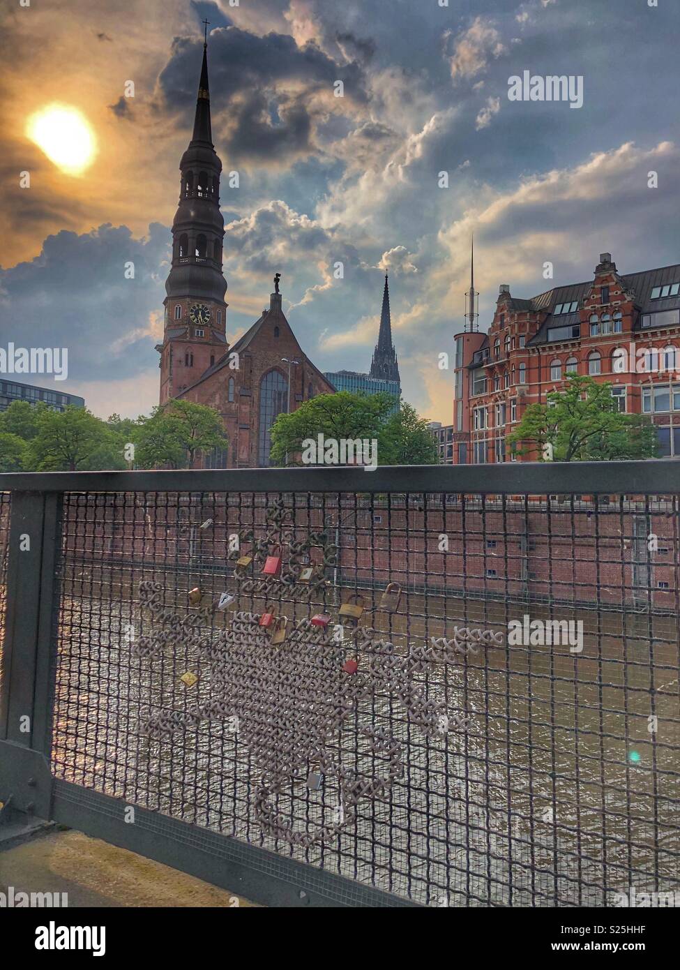 Sunset, church, canal and love locks in Hamburg, Germany. - Smartphone Captured Stock Image