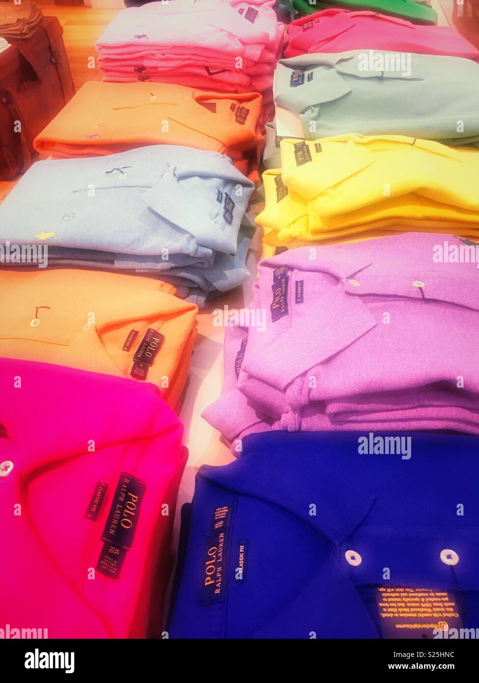 Display of neatly folded vibrant colored polo designer shirts in a department store, United States - Smartphone Captured Stock Image