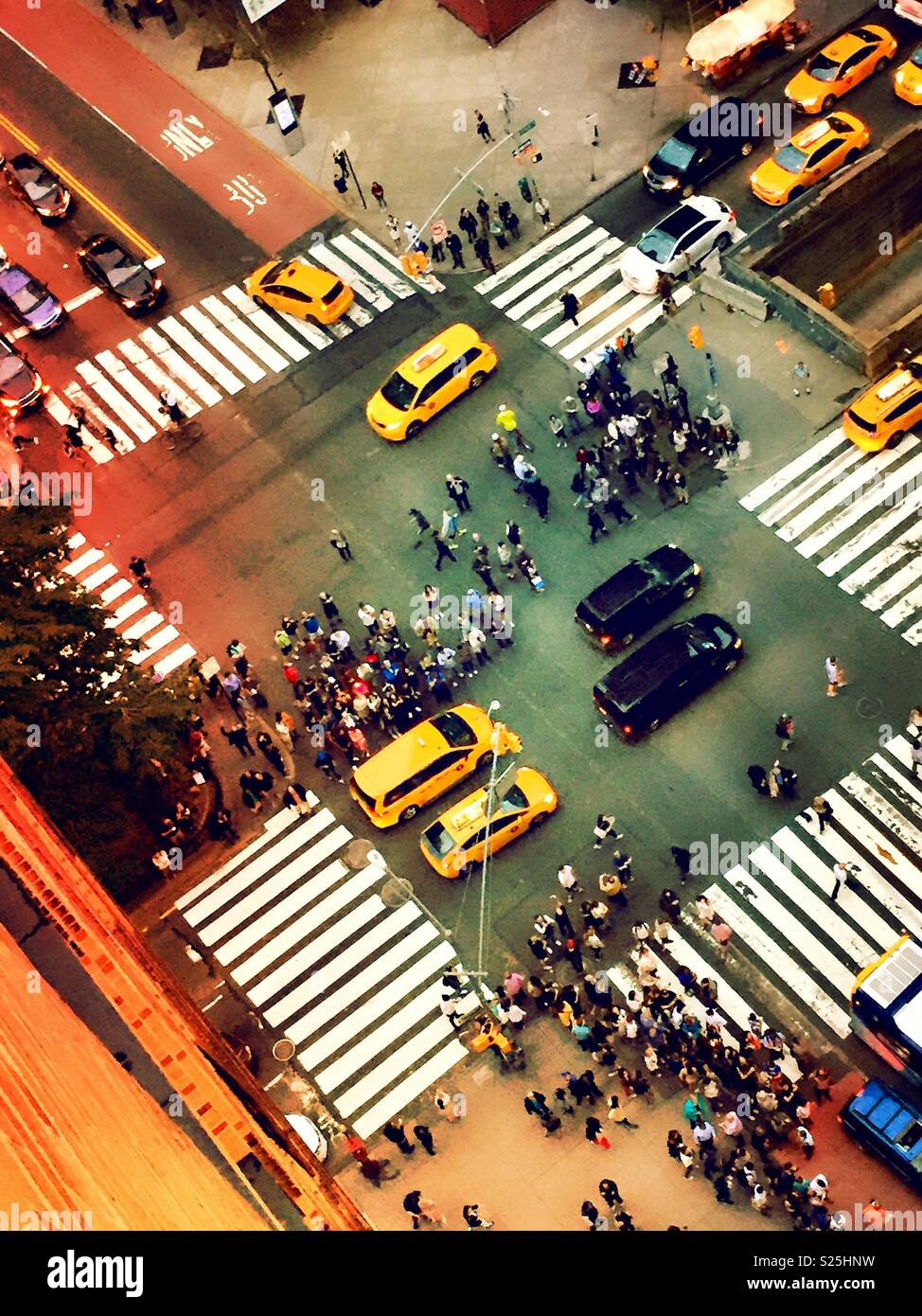 Spectators viewing the sunset directly down the street in midtown Manhattan, Manhattanhenge or canyon of light, NYC, USA - Smartphone Captured Stock Image