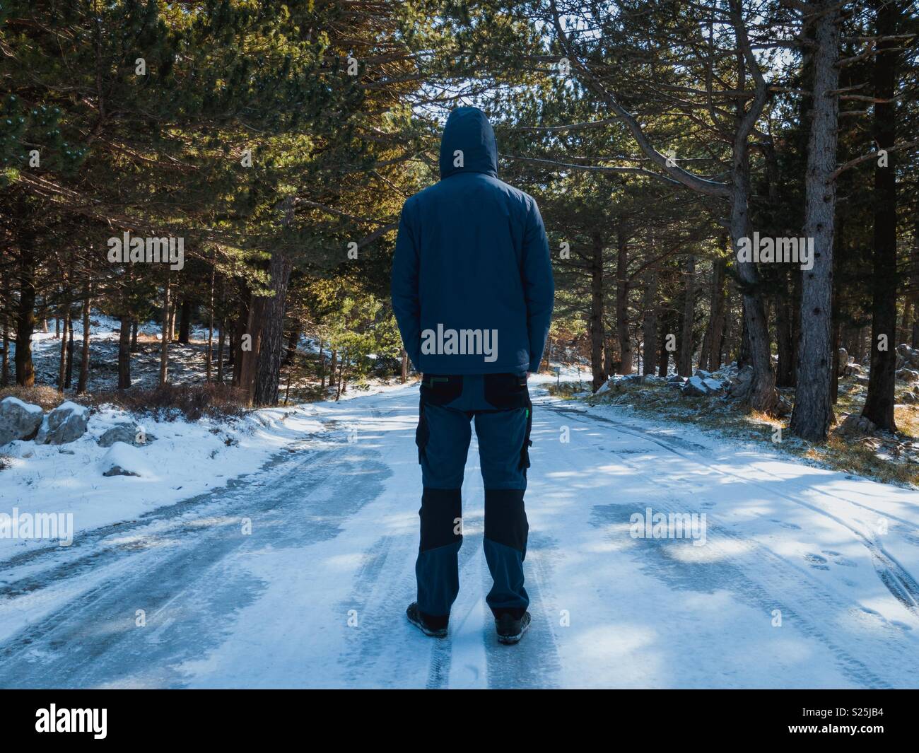 Man in warm clothes on the middle of frozen road Stock Photo