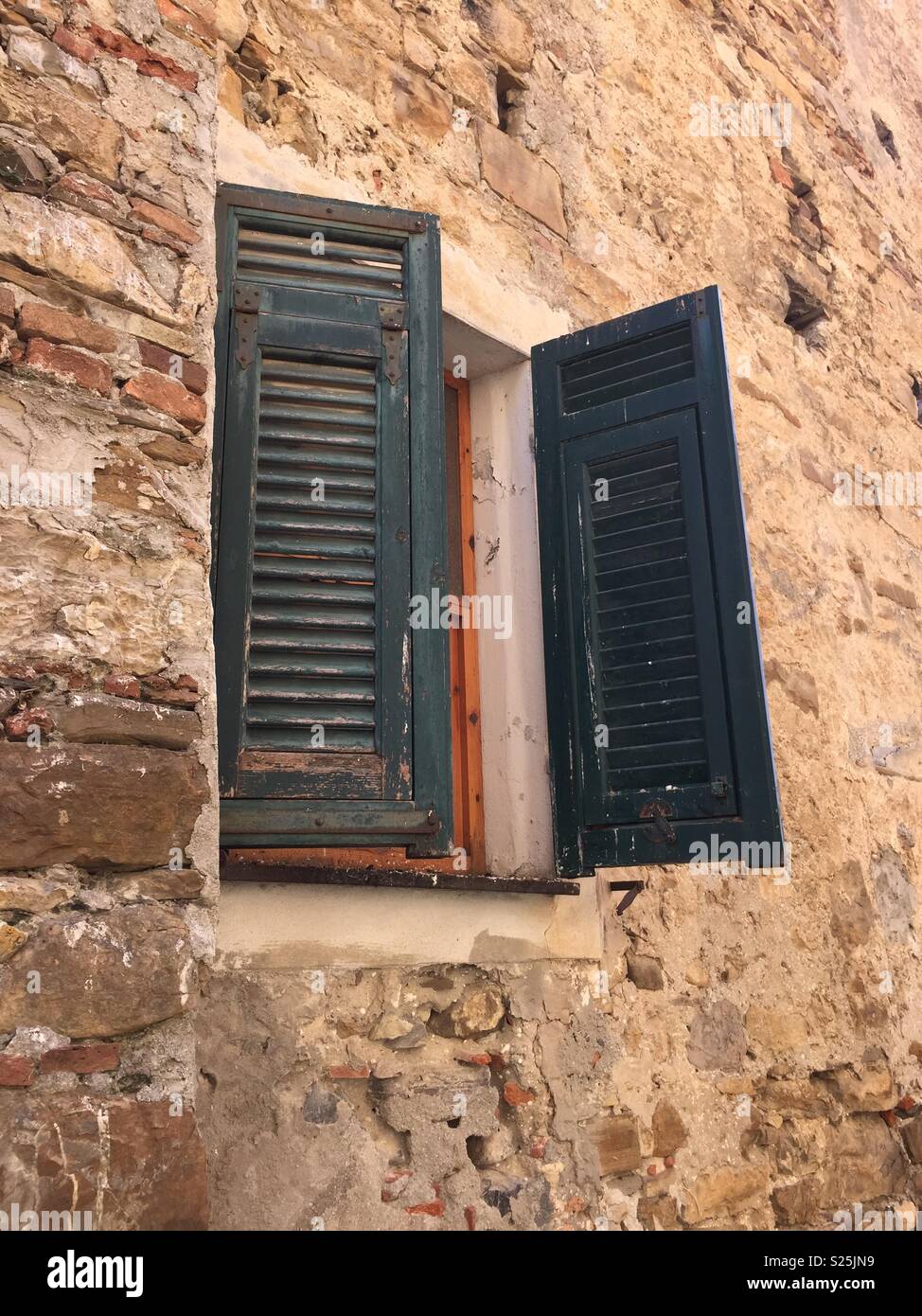 Medieval Window with green shutters. Stock Photo