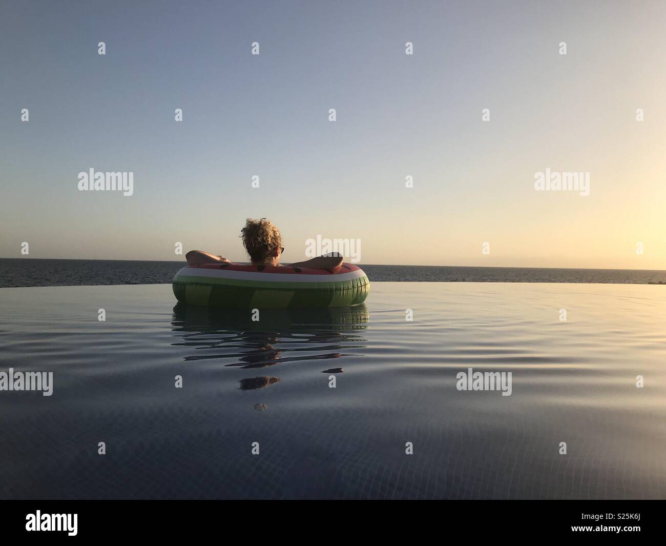 Floating in a rubber ring looking out to sea Stock Photo