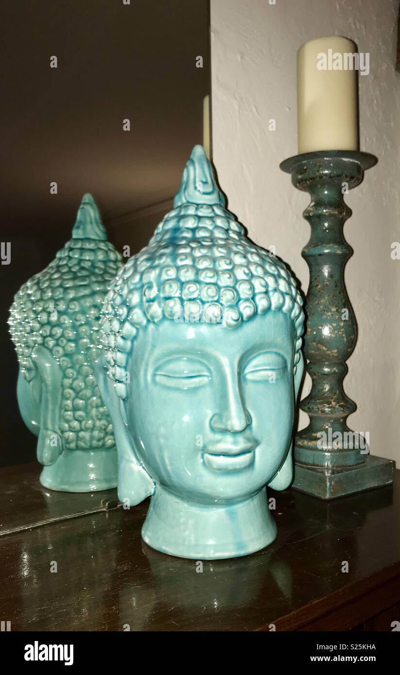 Tibetan turquoise ceramic art statue and candle holder decor on wooden mantel Stock Photo