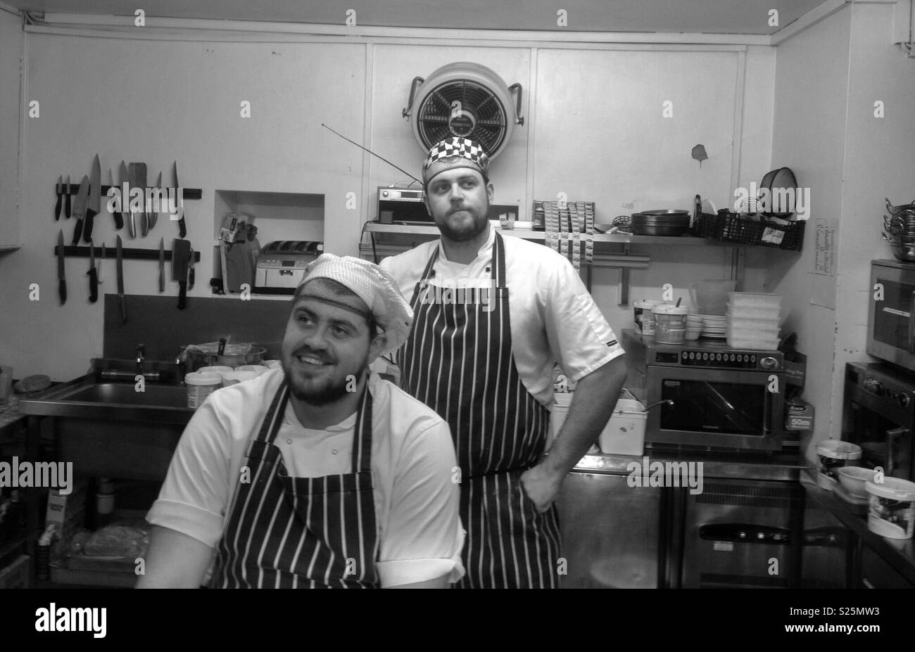 Two proud chefs in their kitchen Stock Photo