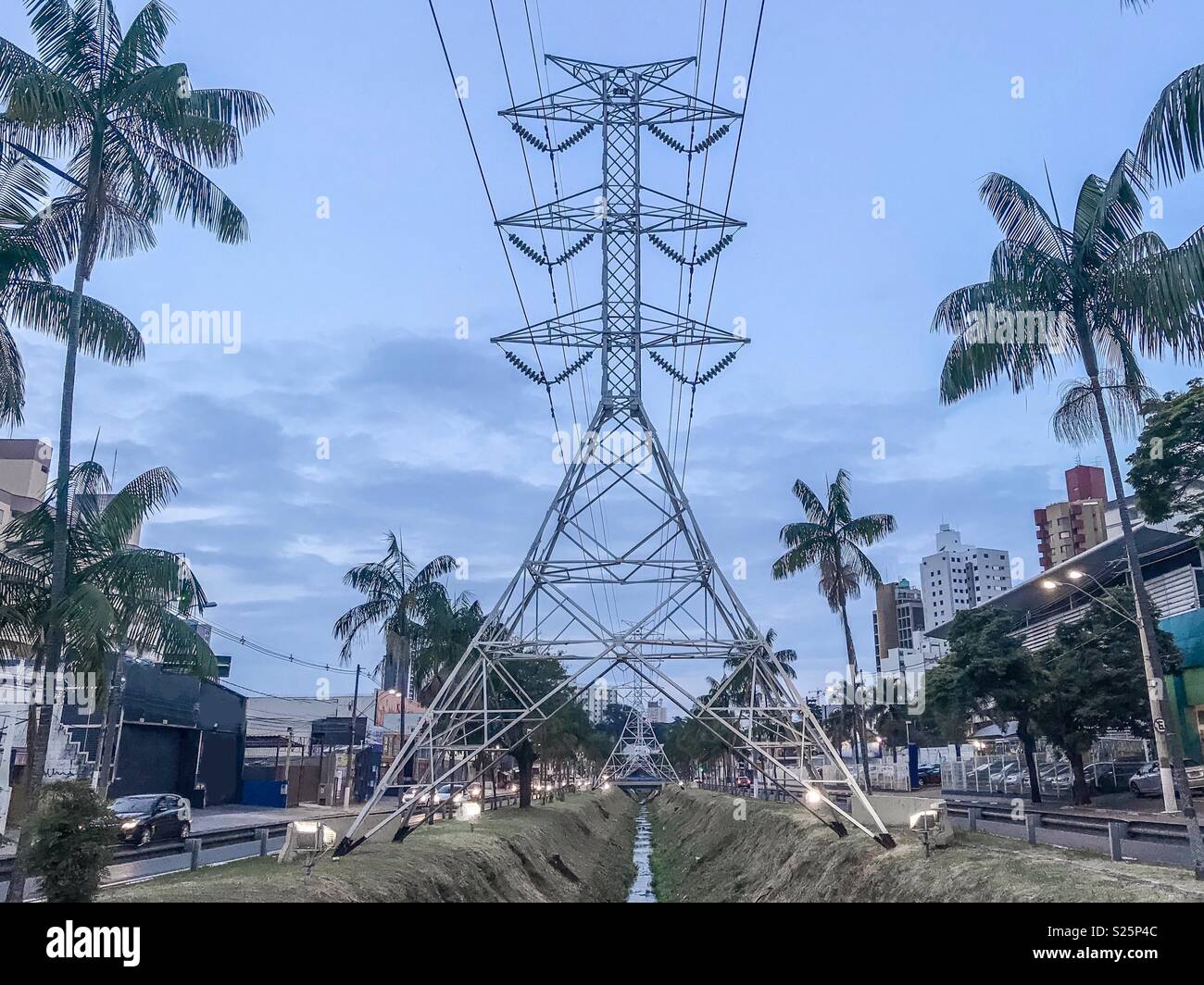 High voltage towers over a water stream in Campinas, SP Brazil - Smartphone Captured Stock Image