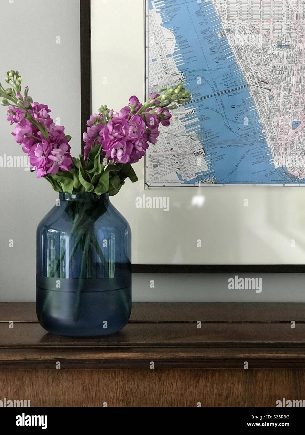 Blue vase, pink flowers and vintage map in interior vignette Stock Photo