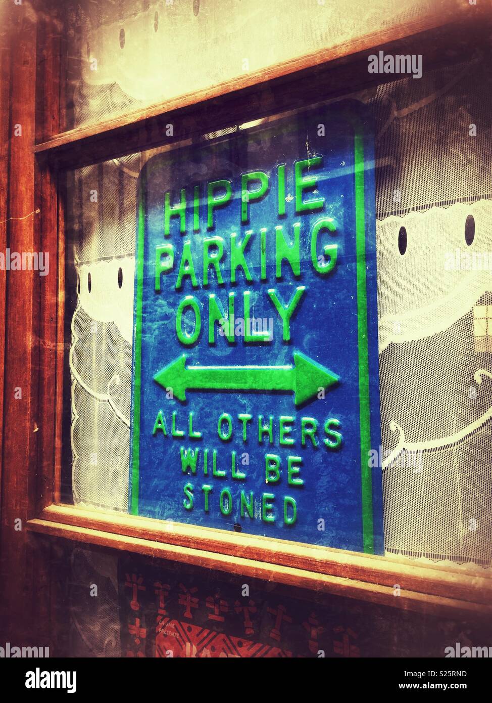 Witty sign in doorway of alternative health food shop reading Hippie Parking Only, All Others Will Be Stoned. - Smartphone Captured Stock Image