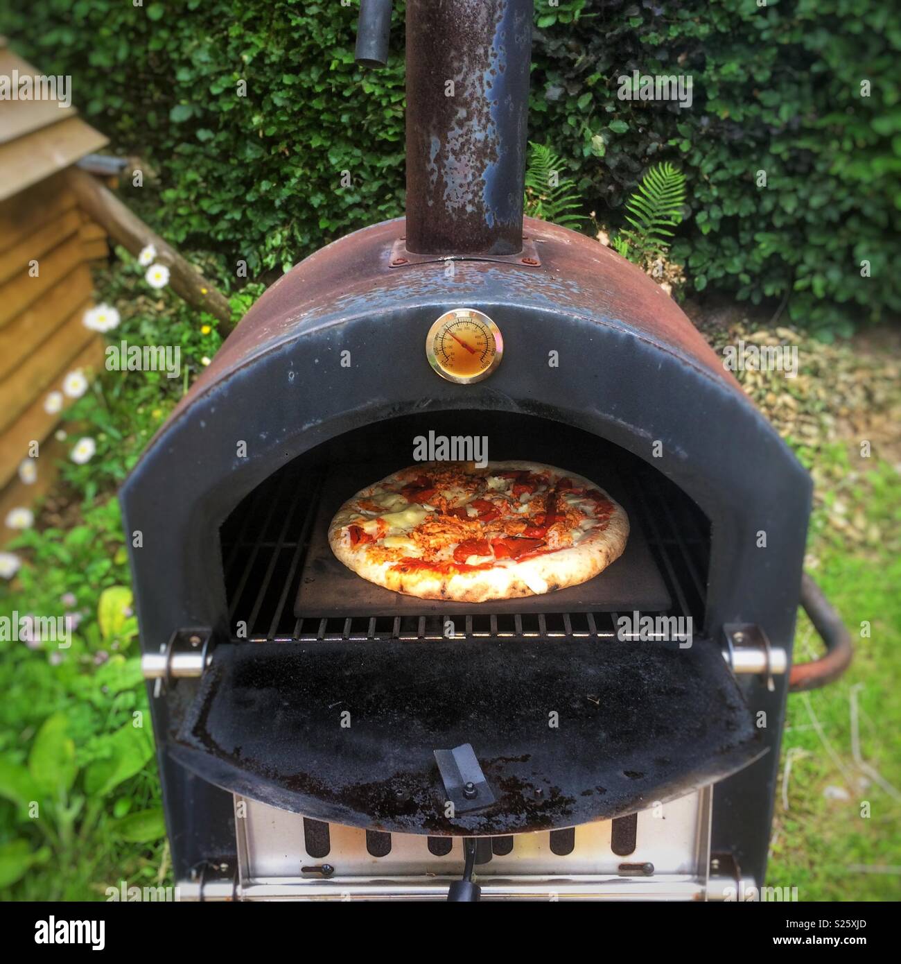 Thermometer with glowing embers in an outdoor wood-burning pizza oven for  cooking and baking Stock Photo - Alamy