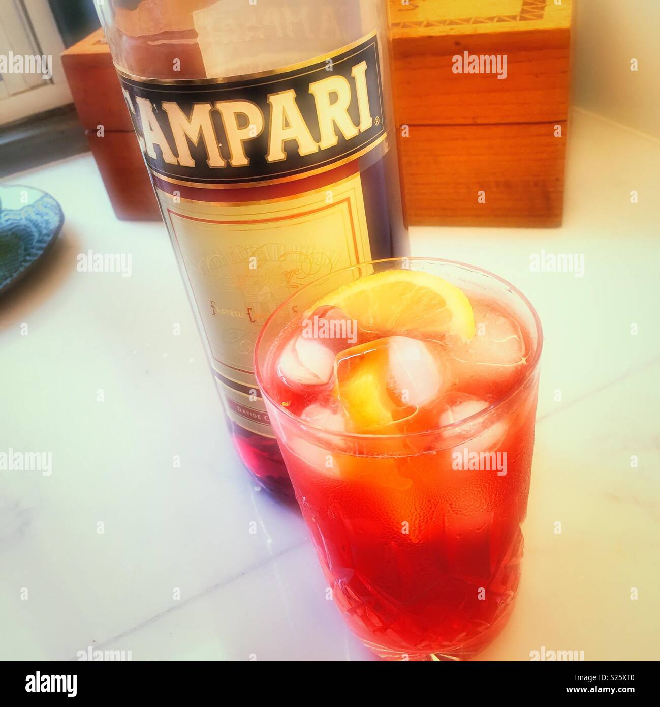 A refreshing summer drink of Campari and soda with a lemon wedge served in a crystal glass Stock Photo