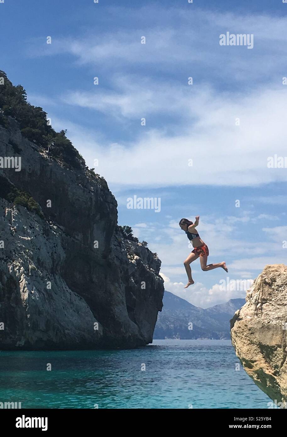 A girl jumping into the sea Stock Photo
