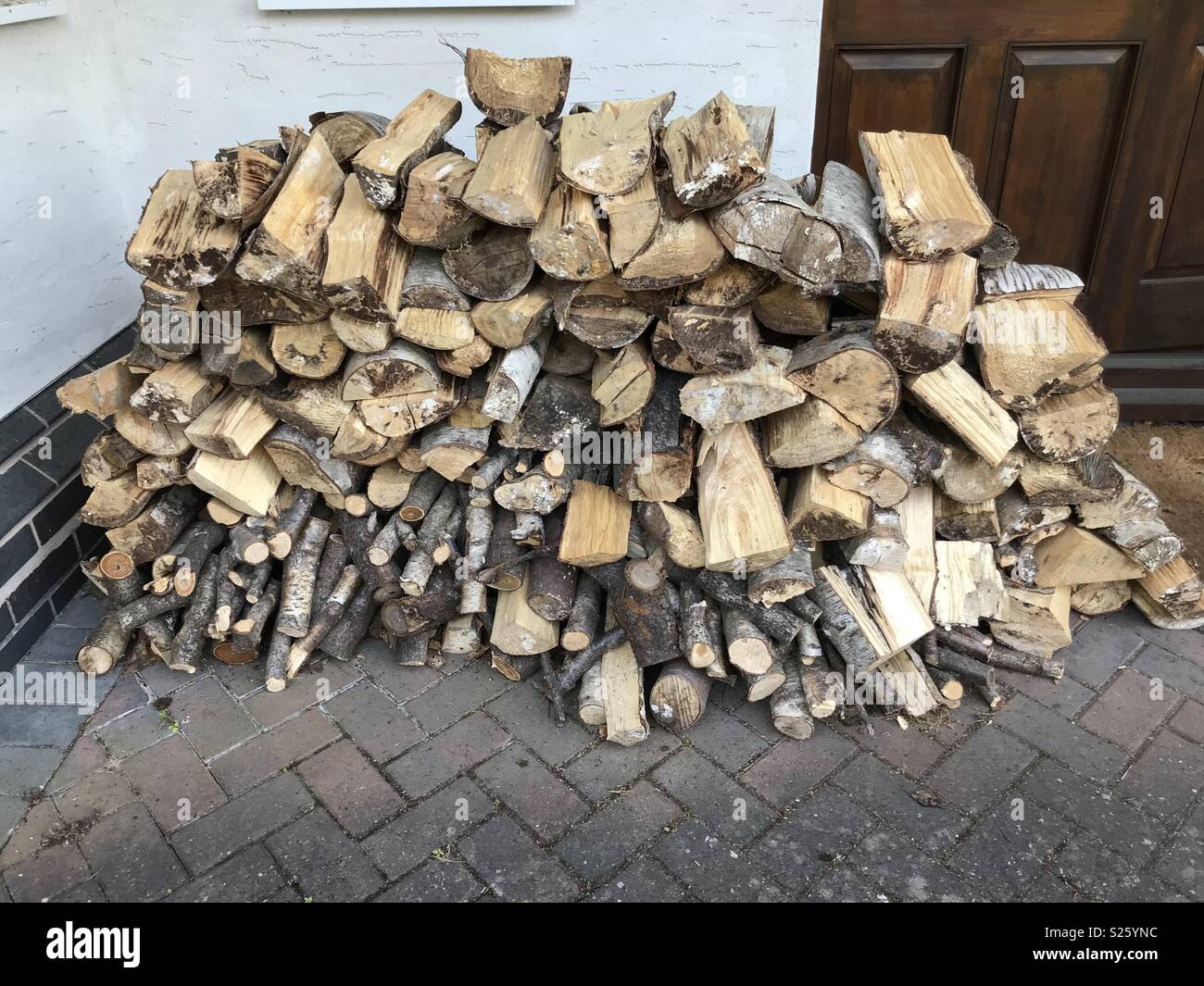 Wood pile drying out in the sun ready to be used in a log burner Stock