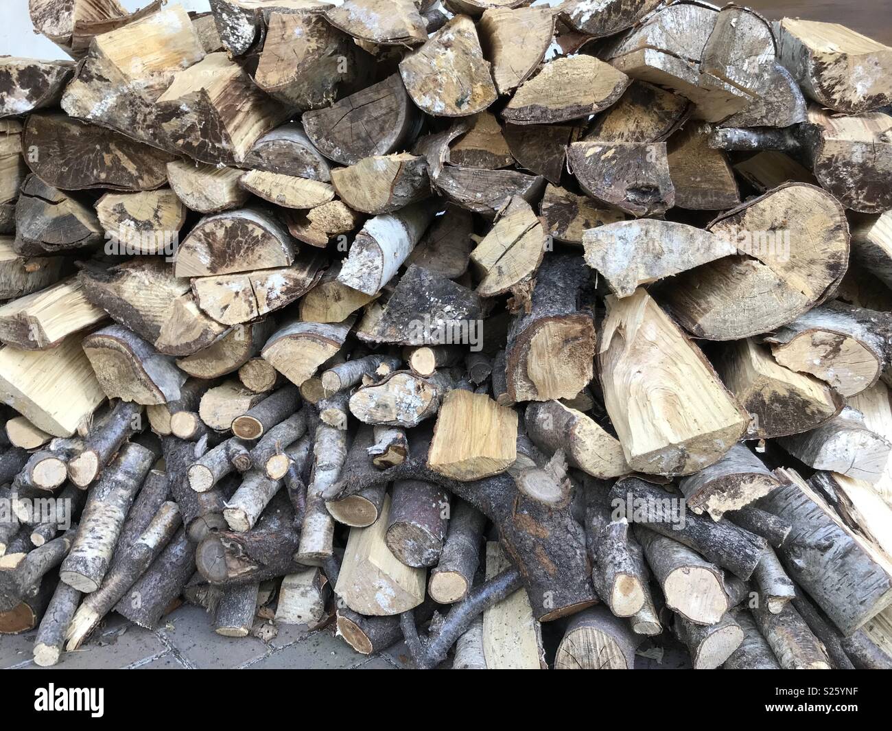 Log pile drying out in the sun ready to be used in a log burner Stock Photo