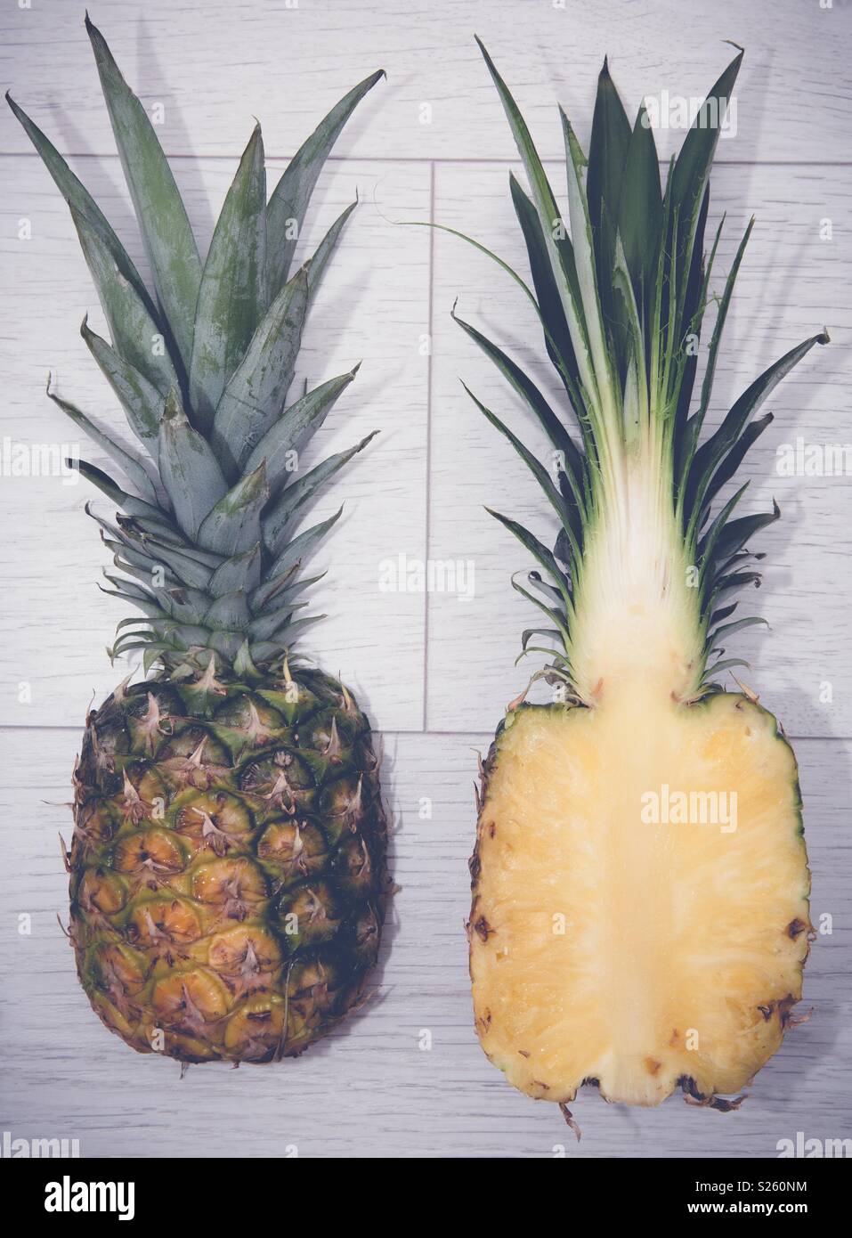 A fresh pineapple sliced in half on a white background - Smartphone Captured Stock Image