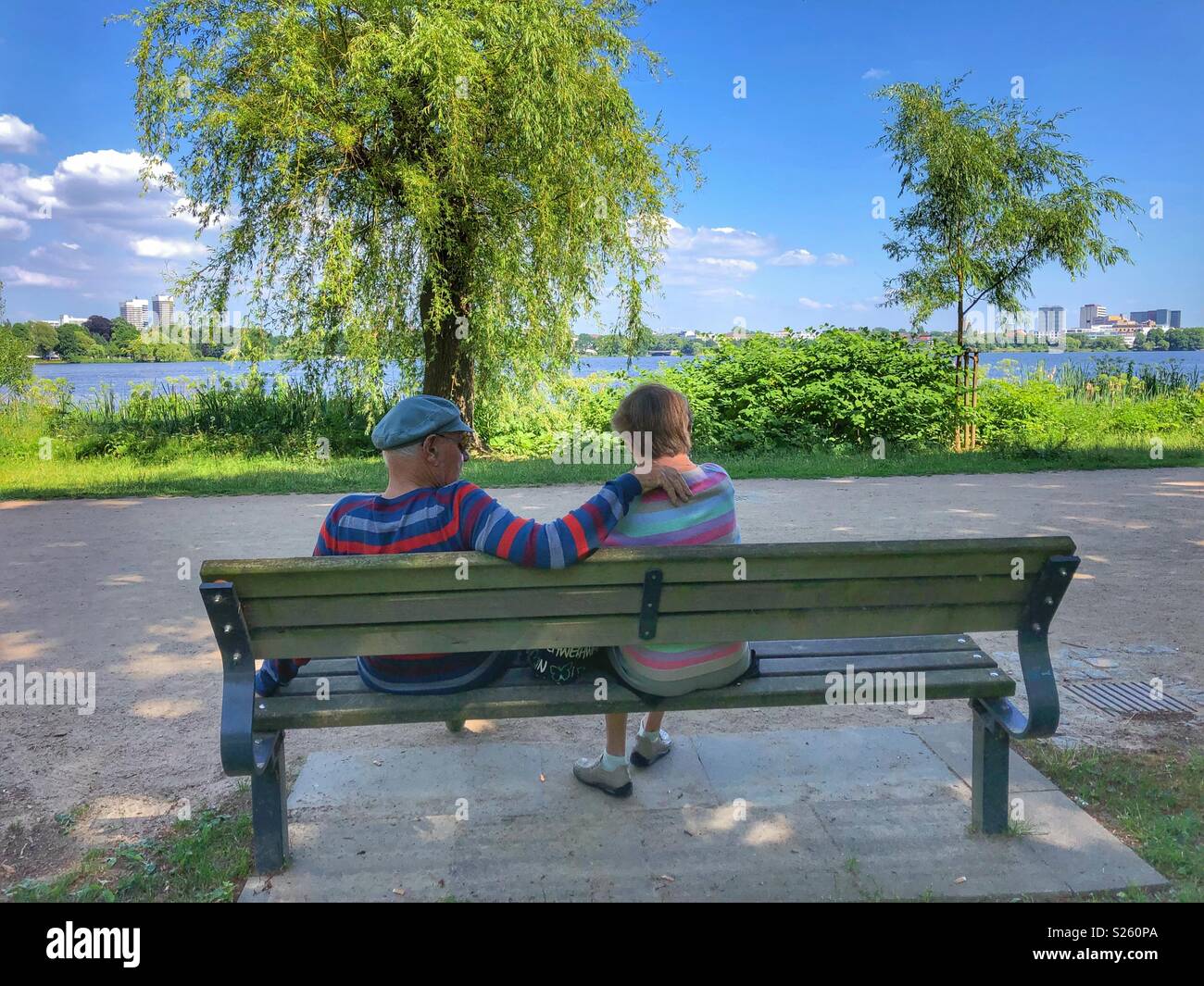 An elderly couple sitting on a park bench in Hamburg, Germany. - Smartphone Captured Stock Image
