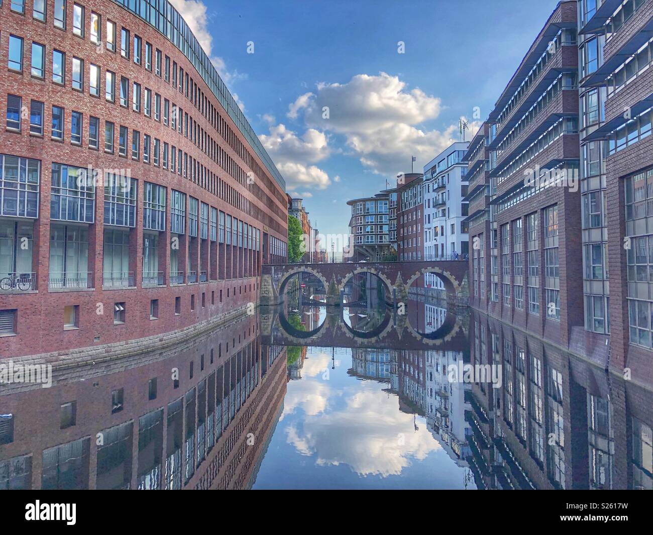 Water reflections of the sky and buildings along side a canal in Hamburg, Germany. - Smartphone Captured Stock Image